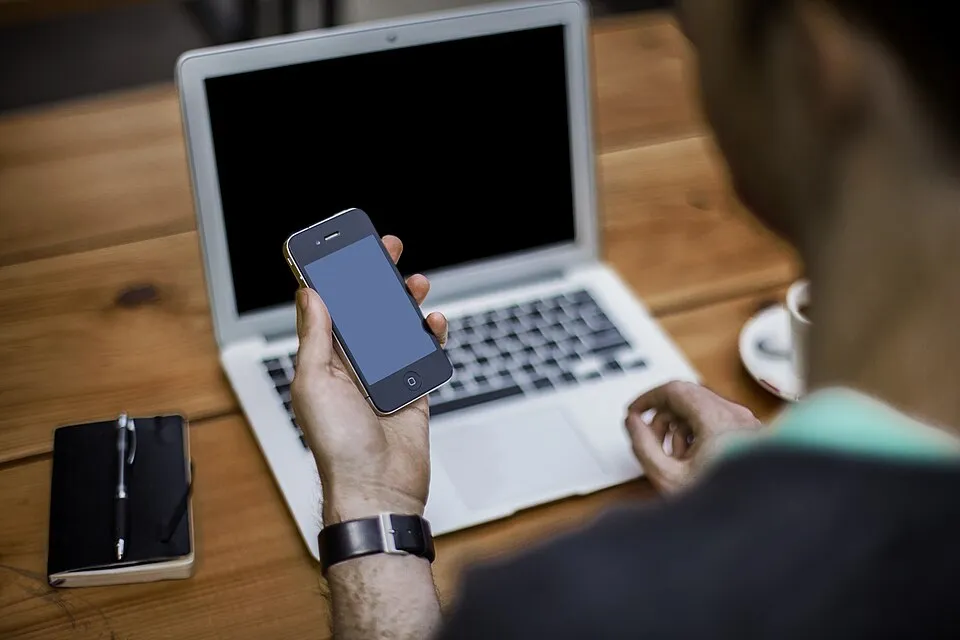 Man with smartphone and laptop (Unsplash).jpg